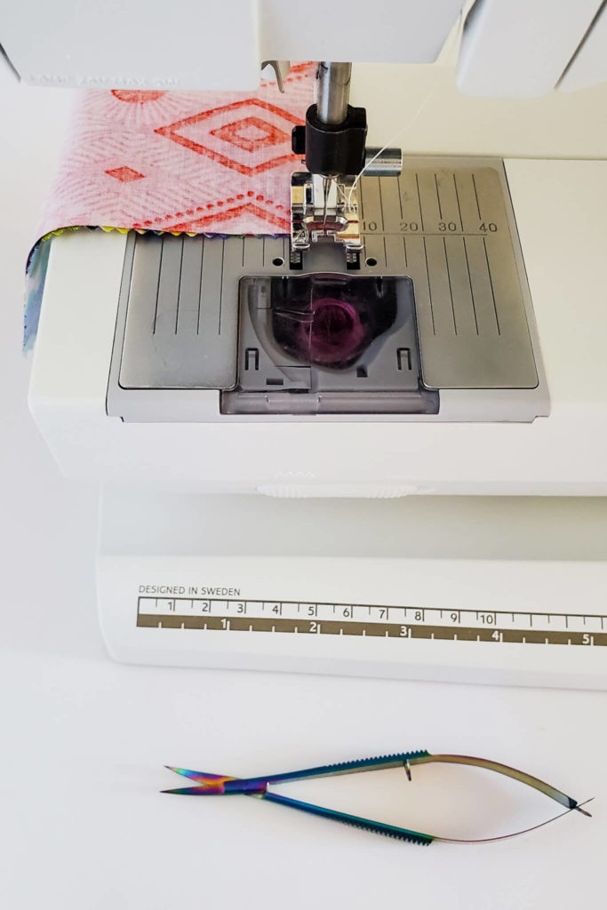 A sewing machine with fabric underneath the foot.